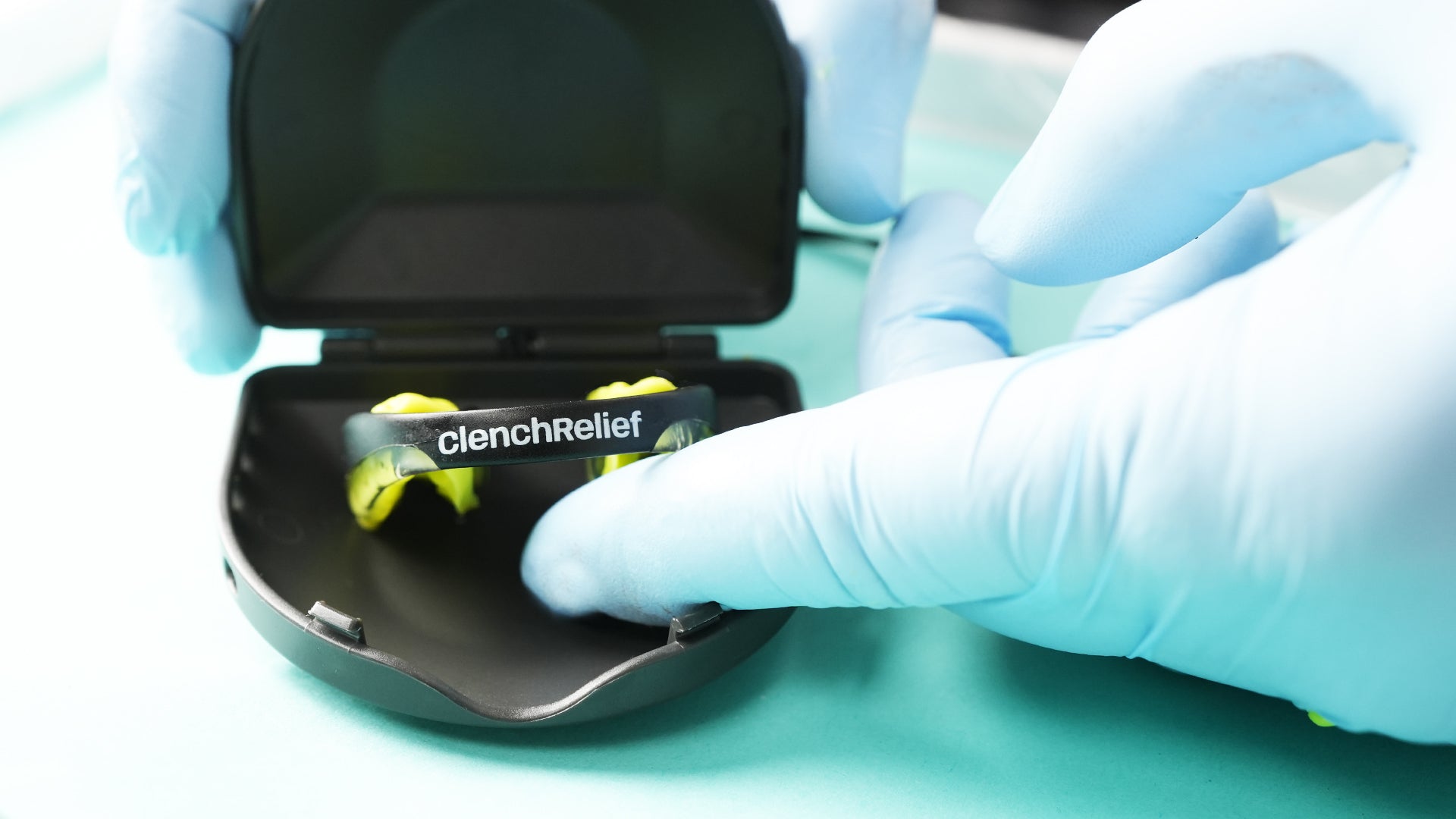 Showcase of the Clench Relief Pro Rx TMJ Mouthpiece sitting in its case on top of a dental tray