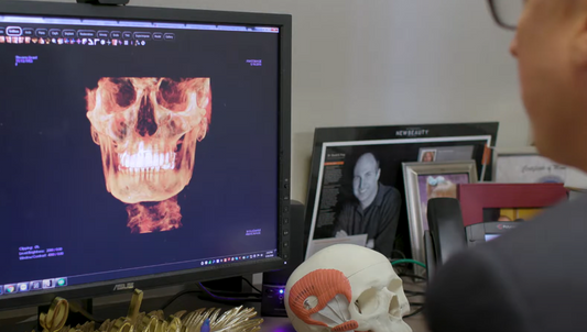 Dr. David Frey in his office examining x-rays of a patient's jaw